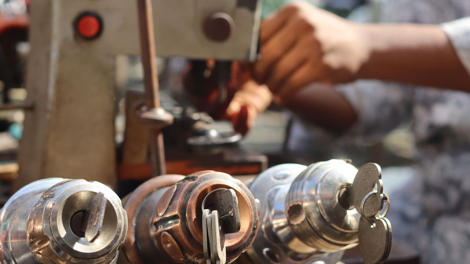 Locksmith working on a car key blank at a workshop bench